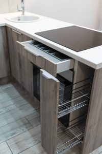 Meuble de cuisine équipé d’un système de rangement coulissant avec des provisions organisées.